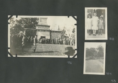 appears to be the same scene and people as in image #179, but taken from a different angle; 3 little girls standing on the sidewalk; view of trees