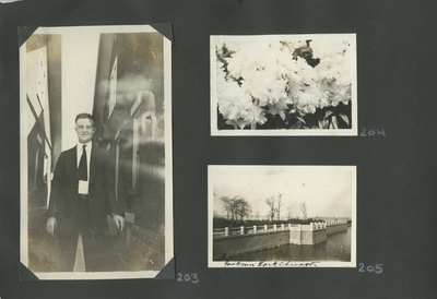 man standing between 2 buildings; flowers; 