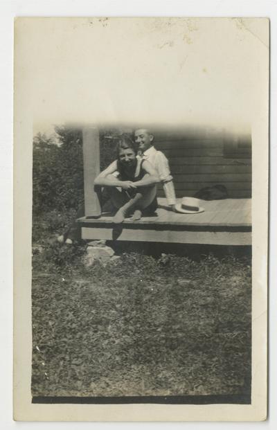 Unidentified young man and woman sitting on a porch