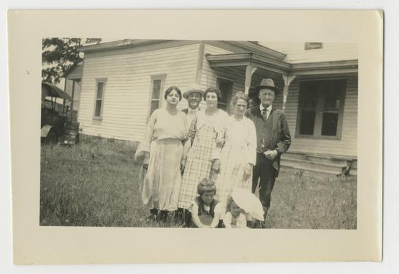 Unidentified family portrait in front of a house