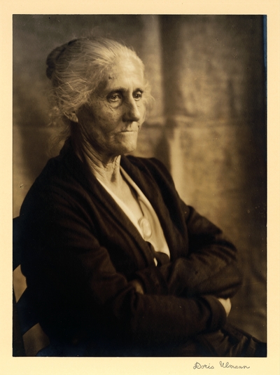 Hannah Smith; Spinner, weaver, singer; Brasstown, North Carolina.  Elderly woman seated in chair, wearing cameo, arms crossed