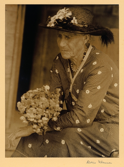 Lydia Ramsey; Sugarlands.  Elderly woman in hat, necklace, and dress, seated with flowers