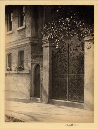 Brick and stone building with iron gate and window boxes