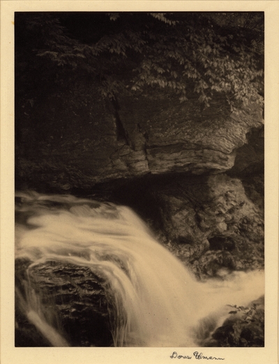 Waterfall with rock cliffs and overhanging trees