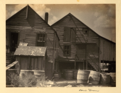 Weathered buildings with barrels in front