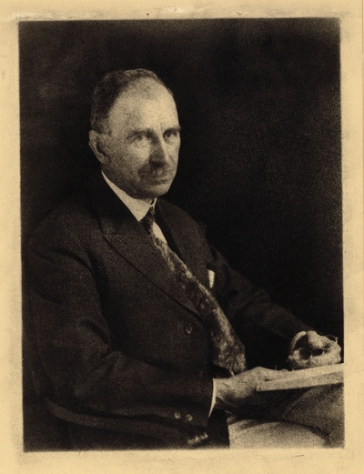 Frederick Villers;  Man with mustache, in coat and tie, seated with glasses and book