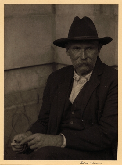 Covey Odhom, Tanner, Luther, Tennessee. Elderly man with mustache, in hat and suit, seated in corner, whittling