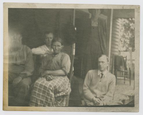 Patients, unknown: Unintelligent looking chap seated at right has trachoma--has not seen for years and sings for a living. Uncle John and Aunt Sis to the left. taken at Pine Mountain in 1916 or 1917