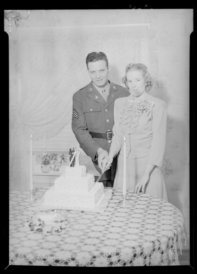 George Ault Jr. & wife; holding knife and cutting cake                             together