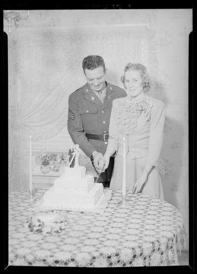 George Ault Jr. & wife; holding knife and cutting cake                             together