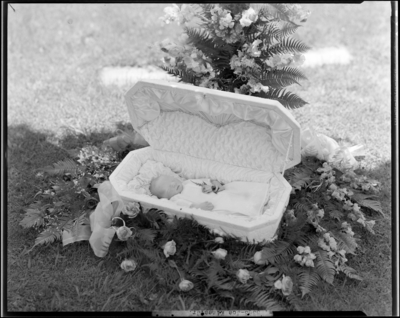 Joe Kines Jr.; corpse (baby); open casket surrounded by                             flowers