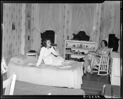 Georgetown College; dorm room; interior; woman lounging on bed;                             woman sitting in rocking chair