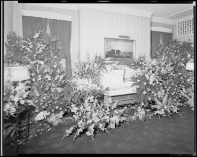 Mrs. H.M. Milton; corpse; open casket surrounded by                             flowers