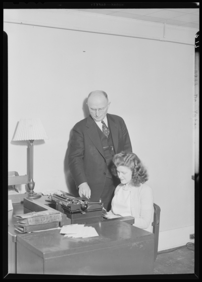 Georgetown College; Dr. Yates standing over woman typing at                             desk