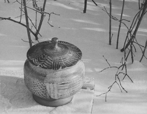 A ceramic pot with a lid sitting in snow, a piece of John Tuska's Alfred University graduate work