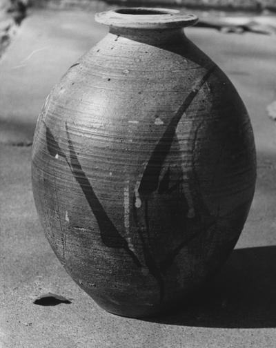 A ceramic pot by John Tuska. An oval shaped pot with a design painted or glazed on the surface