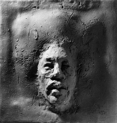 A ceramic tile relief of a male head entitled 