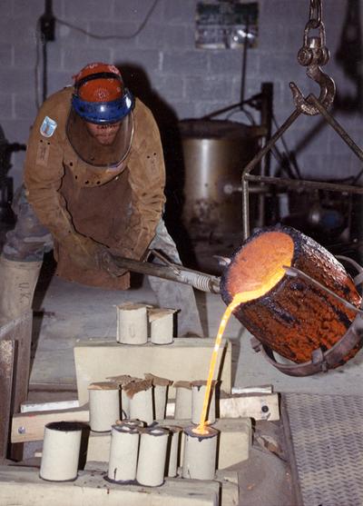 Scott Oberlink pouring bronze from a crucible in the University of Kentucky foundry for the casting 