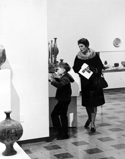 A young boy and woman viewing art in an exhibit entitled 