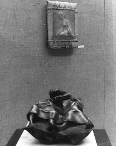 A ceramic pouch figure vessel and a bronze figure sculpture at an exhibit in the Spindletop Research Center