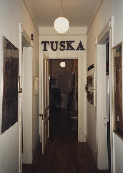 An image of a hallway hung with Tuska artwork at the opening of the Tuska Gallery, which was the home of John Tuska