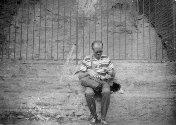 An image of John Tuska sitting on steps in the Coliseum in Rome, Italy. The photograph was taken by Seth Tuska