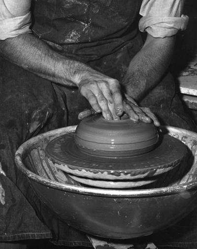 An image John Tuska shaping a clay pot on a potter's wheel