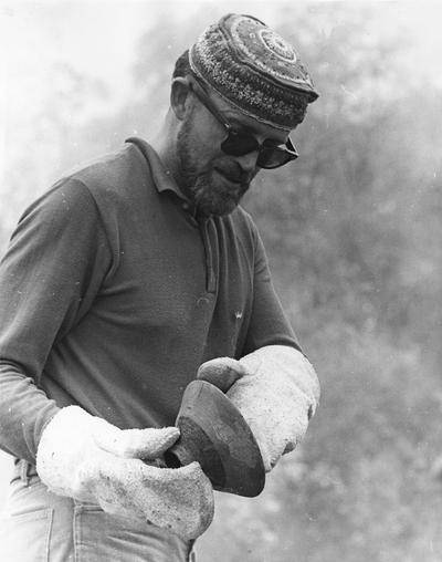 John Tuska examining a clay vessel after a raku firing