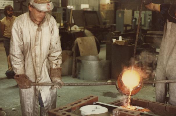 John Tuska and an unidentified person pouring for a cast at the University of Kentucky foundry. The photograph was taken by Ted Bronda