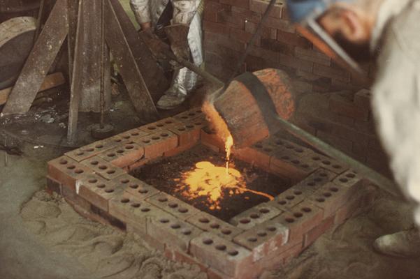 John Tuska and Jack Gron finishing a pour for a cast at the University of Kentucky foundry. The photograph was taken by Ted Bronda