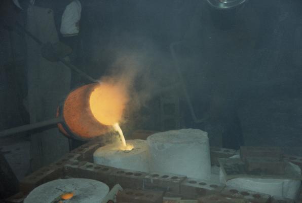 An unidentified person and Jack Gron pouring metal in the University of Kentucky foundry. The photograph was taken by Zig Gierlach