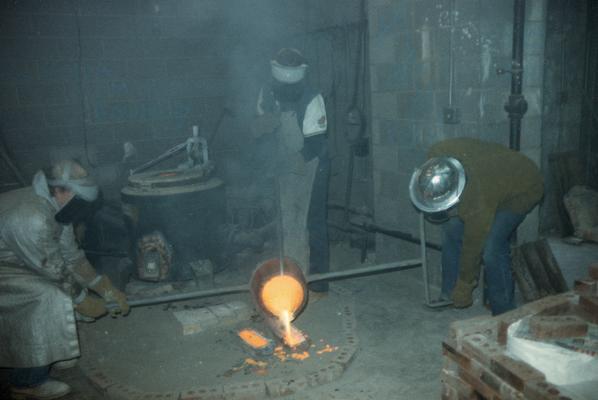 John Tuska, an unidentified person and Jack Gron finishing pouring metal in the University of Kentucky foundry. The photograph was taken by Zig Gierlach